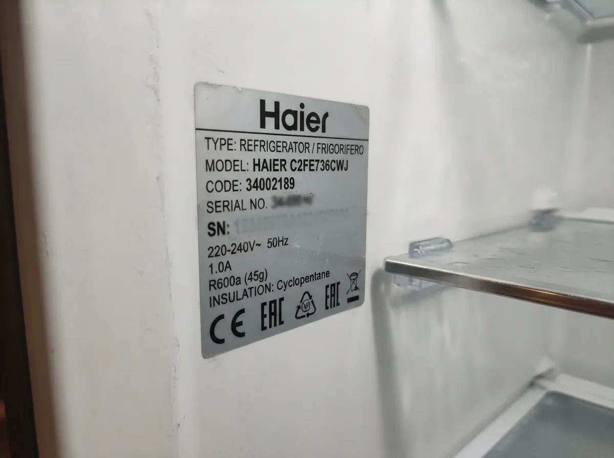 Шильдик с моделью холодильника Haier на внутренней стенке холодильной камеры